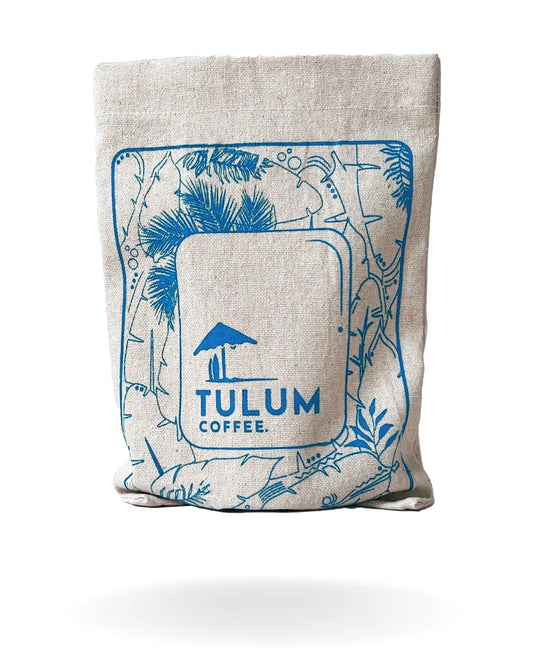 A close-up of Arabica coffee beans by Tulum Coffee which is Kuttinkhan Washed in Blue cloth bag with fruity and Floral Flavour Notes. 