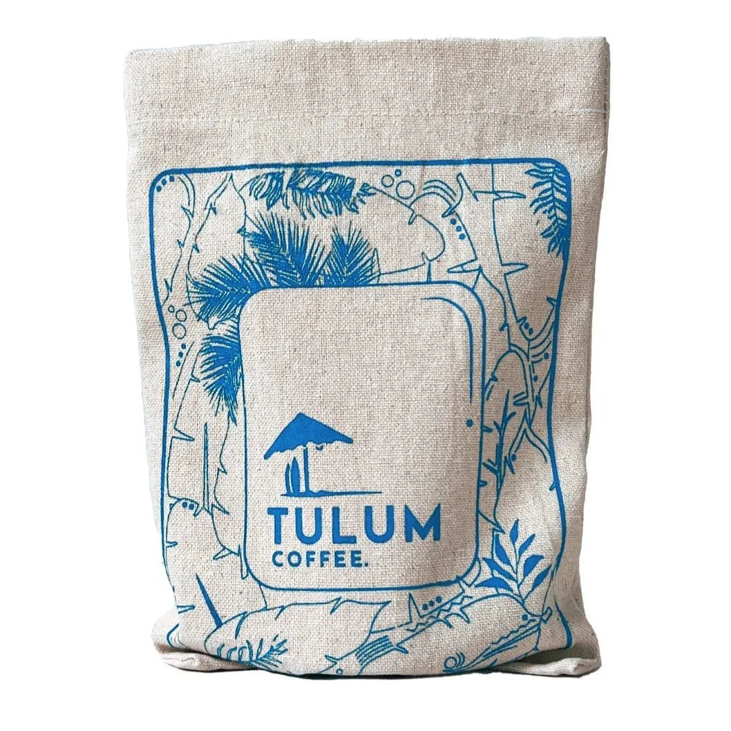 A close-up of Arabica coffee beans by Tulum Coffee which is Kuttinkhan Washed in Blue cloth bag with fruity and Floral Flavour Notes. 